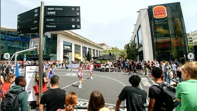 Outdoor court at the 3x3 Westfield Glòries packed with spectators, with the Burger King and Carrefour of Plaça de les Glòries behind