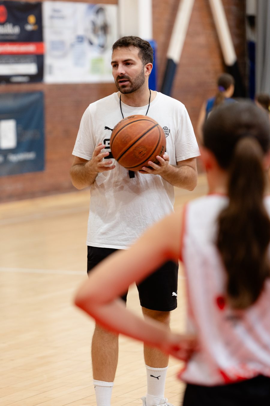 Entrenador del campus explicando un ejercicio con el balón