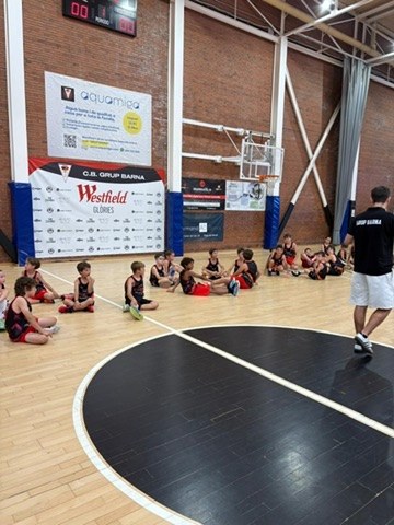 Niños de la Cistella Petita sentados escuchando al entrenador