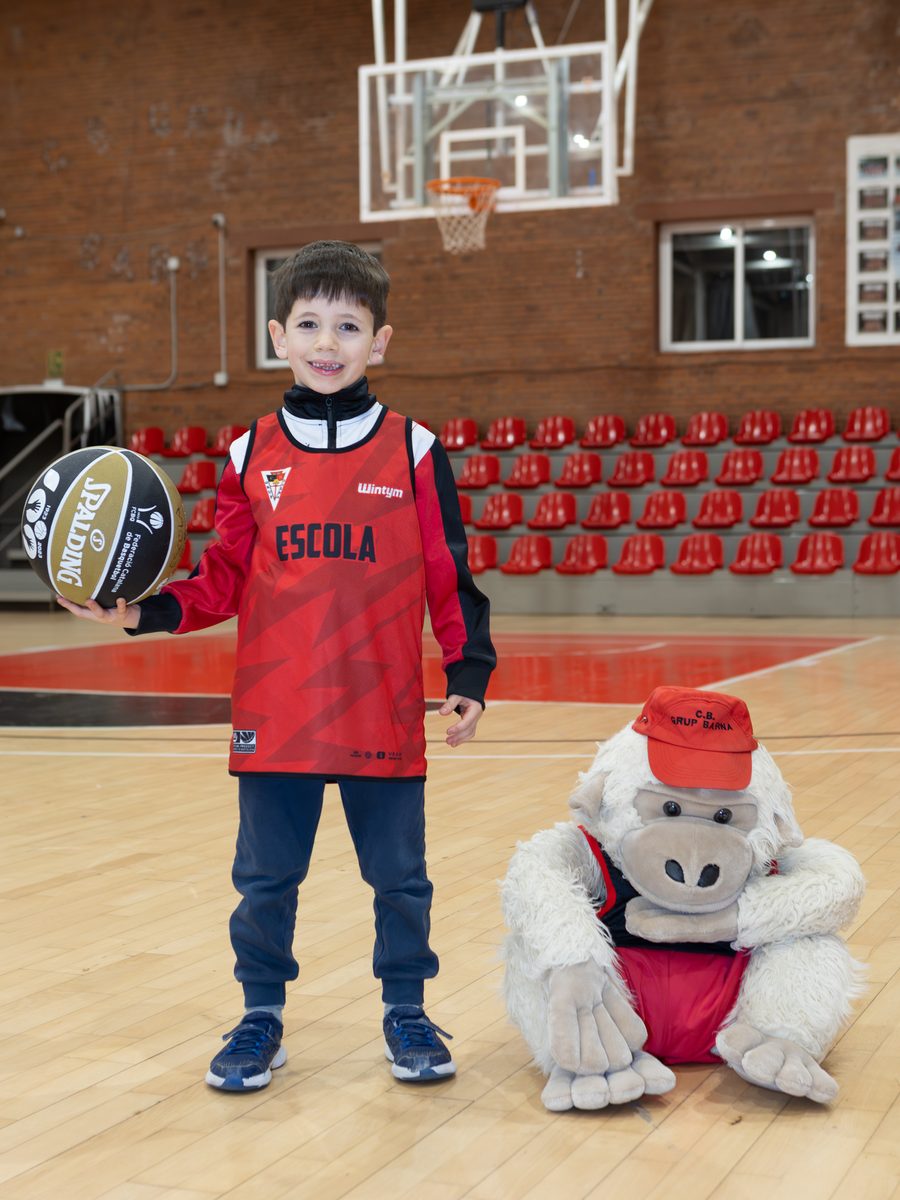 Jugador de l'Escoleta amb la mascota del CB Grup Barna a La Nau del Clot