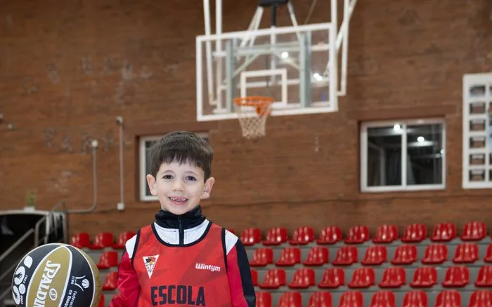 Nen petit de l'Escola de Bàsquet del CB Grup Barna amb la pilota, a la pista