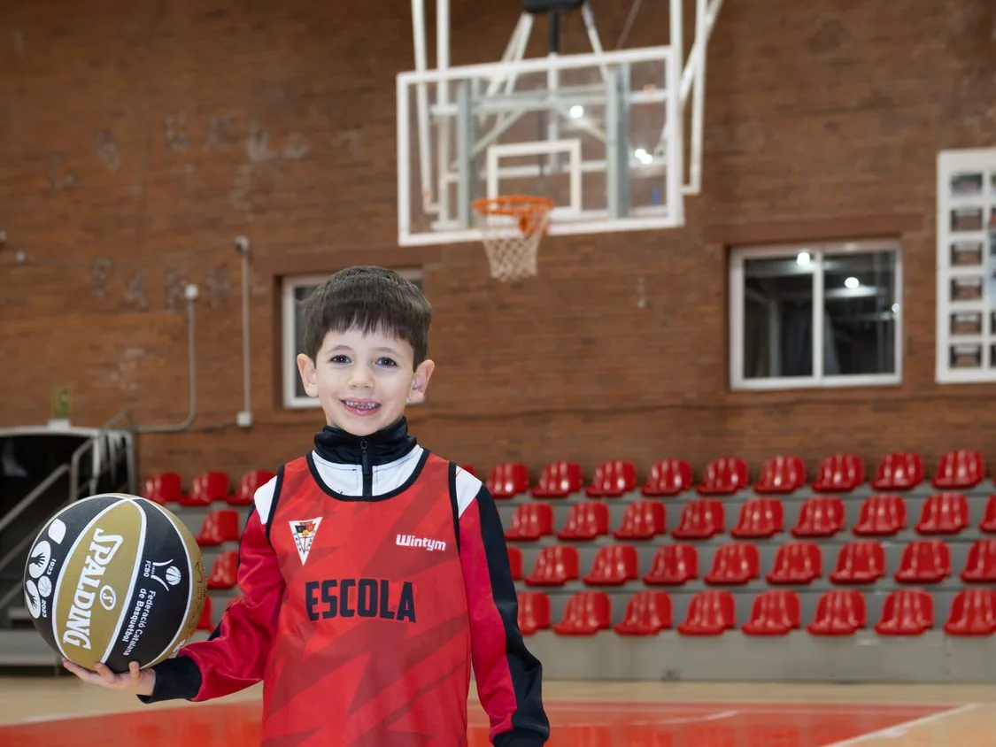 Nen petit de l'Escola de Bàsquet del CB Grup Barna amb la pilota, a la pista