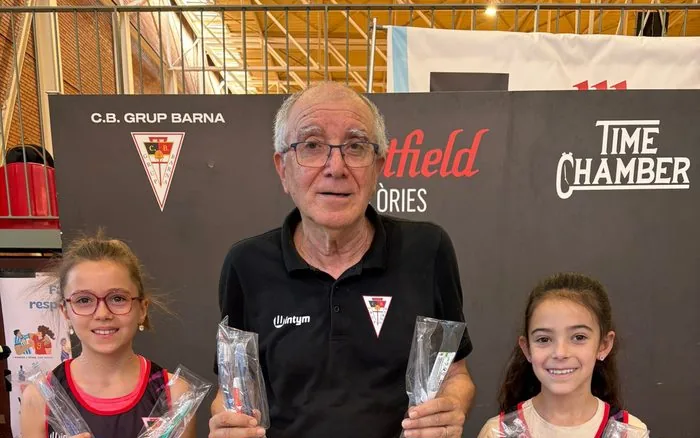 Julio Torralba, fundador del CB Grup Barna, amb dues jugadores de l'escola
