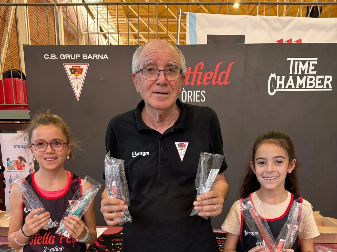 Julio Torralba, fundador del CB Grup Barna, amb dues jugadores de l'escola